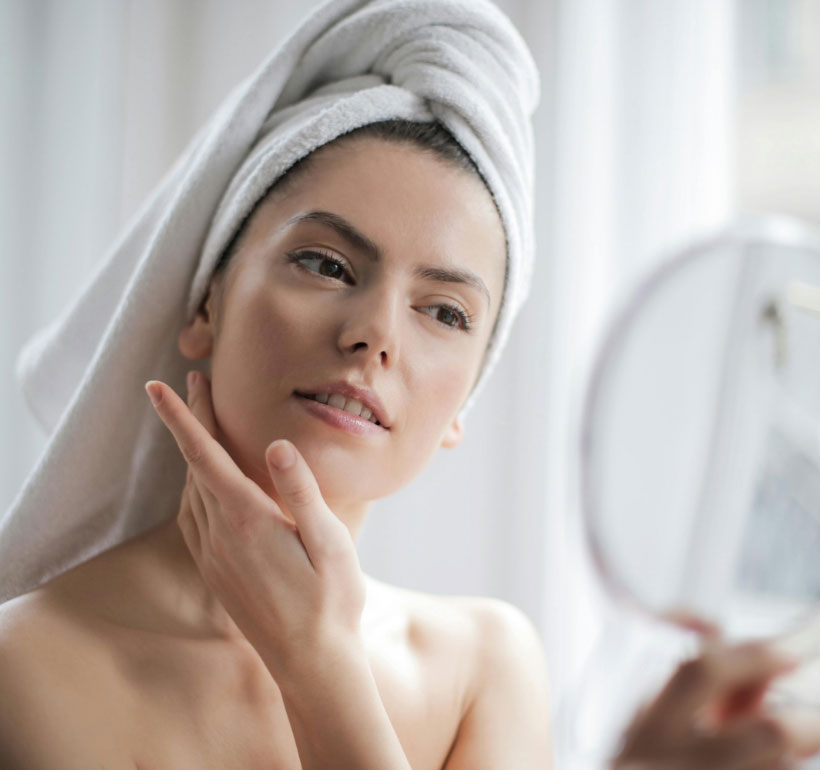 Woman checking skin in the mirror